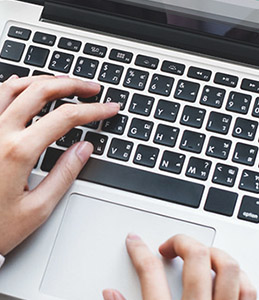 person's fingers typing on a keyboard